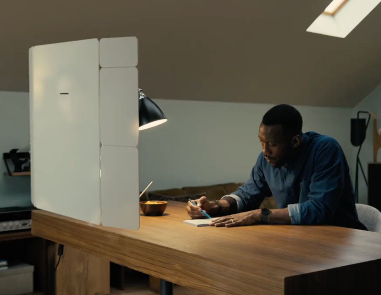 In dieser Szene sitzt der Hauptdarsteller an seinem Schreibtisch. Vor der Person schwebt ein großes, virtuelles Display, welches im Film via CGI (Computergrafik) realisiert wurde.